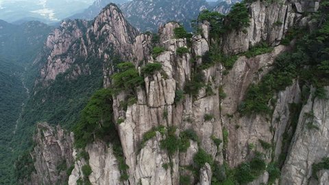 Tilting rising drone shot of surreal pillars and rock formations in Huangshan (Yellow Mountain) national park, one of China's most iconic landmark destinations
