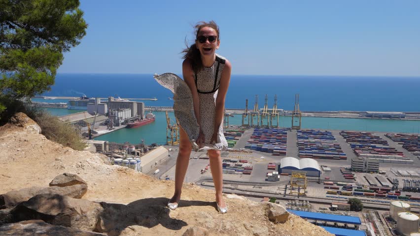 Happy laughing woman playing with her flying dress like Marilyn Monroe. Flapping skirt fly up, Barcelona, Spain