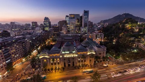 Day to night sunset timelapse hyperlapse of the historic national library of Santiago Chile in city downtown near Santa Lucia. Biblioteca Nacional de Chile. Skyscraper building in background.