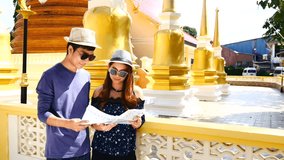 Travel Video A couple of blogger tourists from Southeast Asia is using the map to find the path of the attraction. Landmark in the old City of Phuket during write travel reviews or vacation in travel