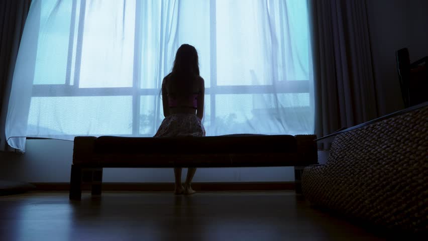 Little teenager looking out of the window in bad weather, silhouette of a fragile teenager girl on the background of a large window | Shutterstock HD Video #1020649225
