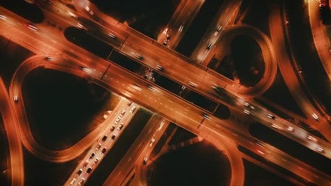 Highway cloverleaf interchange intersection (junction) with ramps, heavy traffic, aerial hyperlapse. A cloverleaf typical  two-level, four-way interchange.
