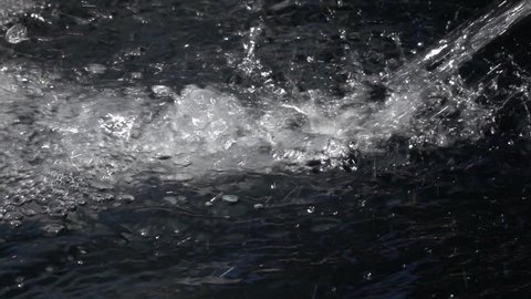 Slow motion of powerful stream, diagonal falling in deep water close up. Vibrant abstract natural gray background with amazing texture. High speed camera shooting.