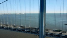 Aerial drone footage of Verrazzano Narrows Bridge, sideways next to the highway (with perspective rotation movement)