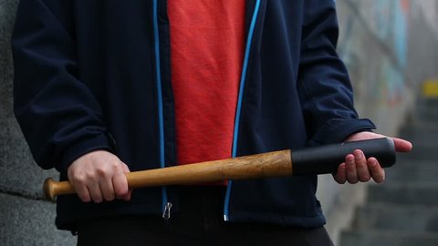 street hooligan is holding a baseball bat