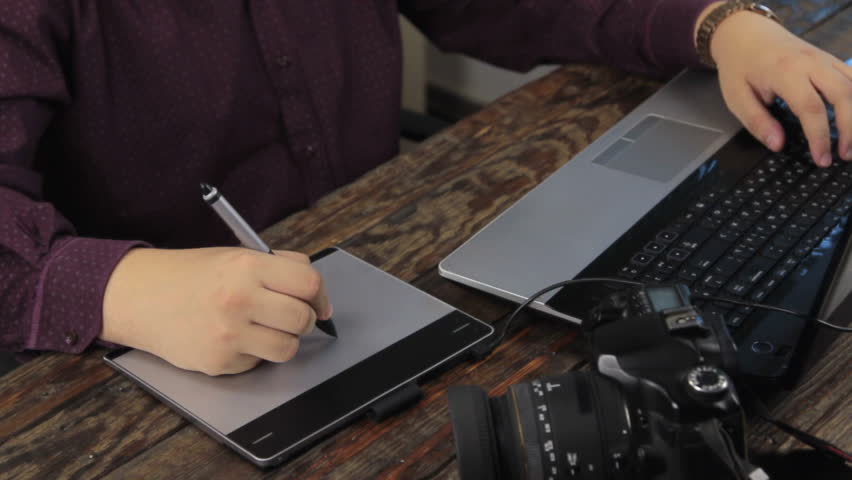 Close-up. Designer works on a graphics tablet. Retouching on computer laptop, a Business & Finance Video by alekleks