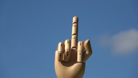 Wooden hand finger symbols  concept middle finger sign in  gesture meaning fuck you or fuck off rotating on  sky background