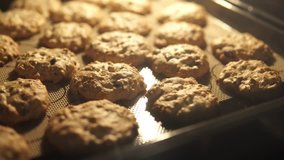 Video 4k fresh cookie with chocolate and almonds in hot oven. homemade cooking.