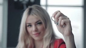 Mortgage concept. Woman in red business suit holding key with house shaped keychain. Modern light lobby interior. Real estate, moving home or renting property. - Powered by Shutterstock - Get 15% off with code: PIKWIZARD15