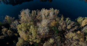  Aerial Drone Opening reveal Shot trees city autumn in golden hour. Aerial  drone shot of autumn trees and countryside over city lake and river on blue and golden hour At Sunset . Drone flying forward