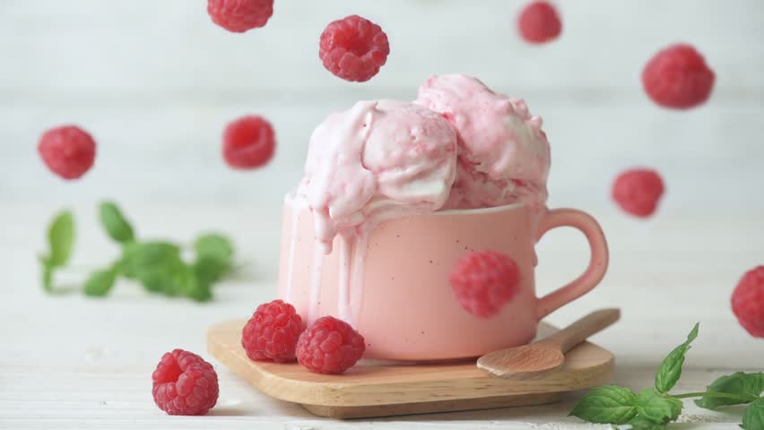 Cinemagraph - Raspberry ice cream in cup on wooden table. Drops of ice cream dripping . Motion Photo.