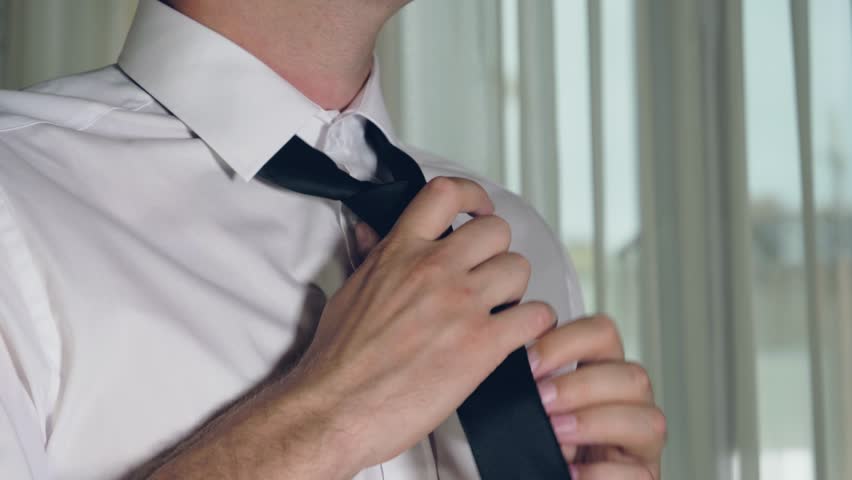 Close-up of adult male hands businessman button up, fixing a black tie, straighten and stretching on a white shirt | Shutterstock HD Video #1020750040