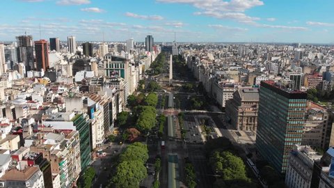 Panoramic Aerial drone view of Buenos Aires obelisk on avenida de Julio in Buenos Aires, Argentina. Shows buildings and skyscrapers with car traffic in the Street below.