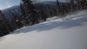 snowboarder rolls touching the snow with his hands and Christmas tree body against the snow-covered taiga. sparkling snow in the frame. a mysterious video with super slow time
