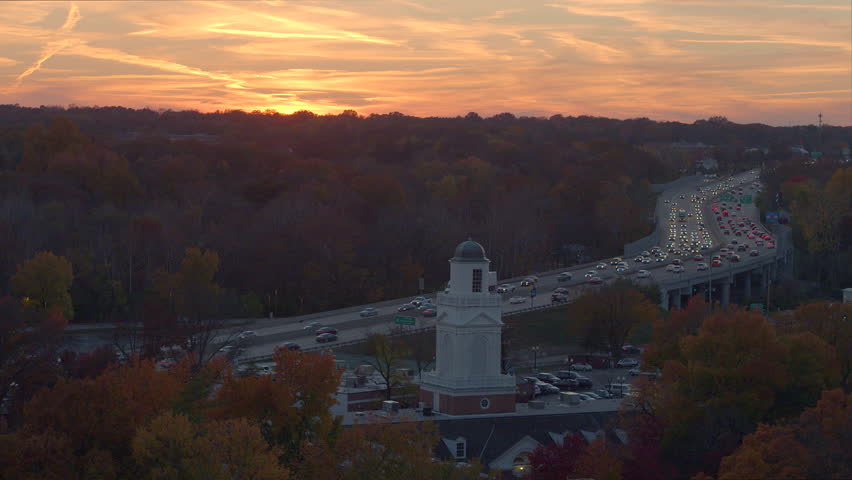 Aerial of sunset over highway descend down to house in neighborhood
