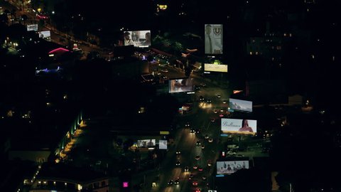 Aerial view of city traffic on Sunset Boulevard with billboards with fake advertisements on a clear night in Los Angeles, California. Shot on 4K RED camera.