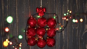 Christmas holiday background of present box made with red shiny round balls and bow at top of them. Top view flatlay real time full hd video footage.