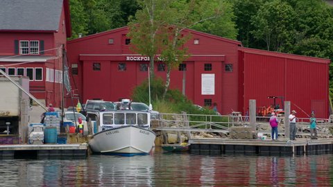 ROCKPORT, MAINE circa July 2017 - Lobster fishing boat unloading it??s daily catch at a quaint New England harbor in Rockport