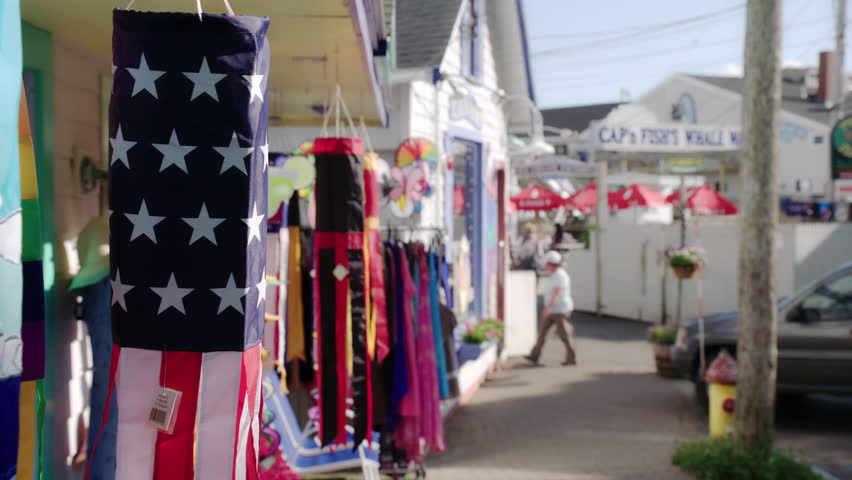 Tourists walk the streets of Boothbay Harbor, Maine on a nice summer day with beautiful clouds in the sky