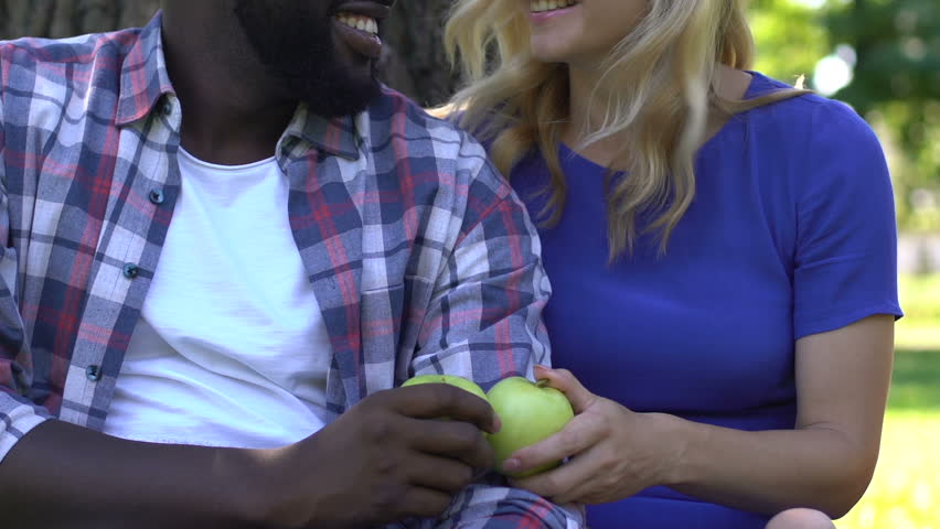 Smiling mixed race couple showing green apples, healthy nutrition concept, diet