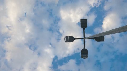 time lapse blue sky with clouds. Over modern electric led street light pole.