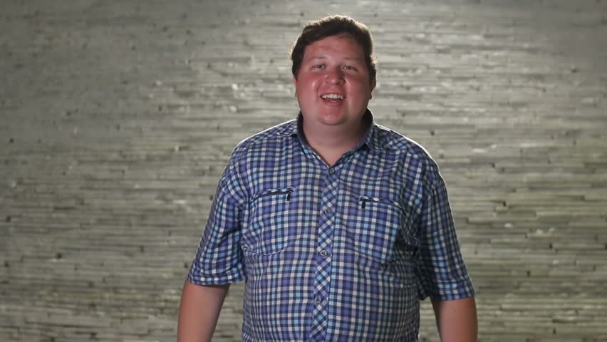 Happy man is dancing and unbuttoning his shirt, in evening outdoor.