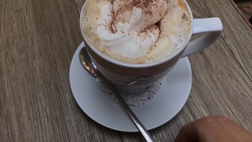 Man stirring a Cappuccino