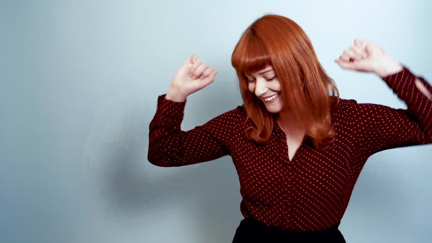 Ginger woman in polka dot shirt dancing