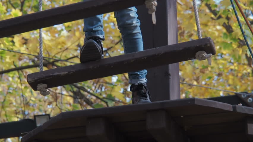 A child in a climbing park. Little girl in an extreme obstacle course.