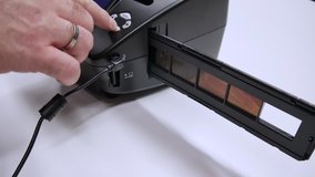 A man digitizes a camera film on a device