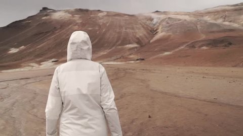 Following Shot of human Confidently Walking on Mars