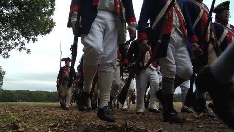 VIRGINIA - OCTOBER 2018 - Reenactment, large-scale, epic American Revolutionary War anniversary recreation -- U.S. Continental Army Soldiers in formation marching as if on parade with Muskets, flags.
