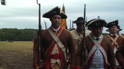 VIRGINIA - OCTOBER 2018 - Reenactment, large-scale, epic American Revolutionary War anniversary recreation -- U.S. Continental Army Soldiers in formation marching as if on parade with Muskets, flags.