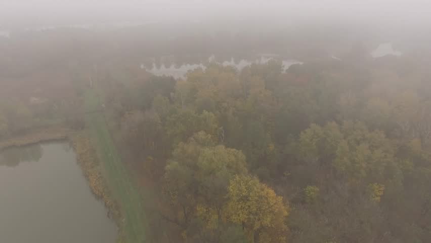 Autumn landscape aerial view of the lake in the fog.