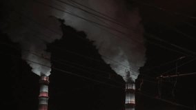 Environmental pollution in Russia. Two smoking pipes. Night industrial landscape. Heat power station somewhere in Siberia.