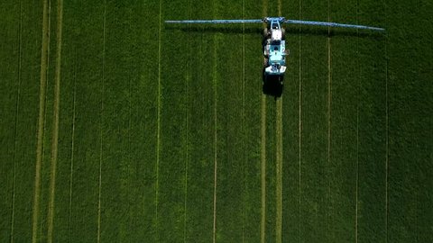 Aerial view Agriculture fertilizer working on farming field, agriculture machinery working on cultivated field and spraying pesticide