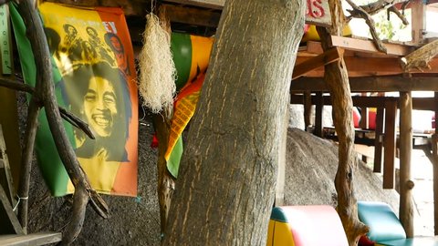 KOH SAMUI, THAILAND - SEPTEMBER 29, 2018 Relaxing jamaican cannabis rasta marijuana reggae bar on the tropical summer beach from. Rastafarian flags with yellow, red and green colors, bob marley.