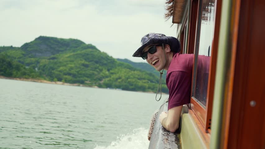 Young Traveller mesmerized by the stunning, mountain surroundings. Having fun on a boat.