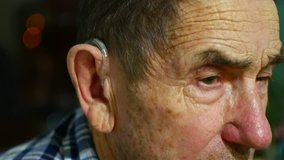 old man using hearing aids