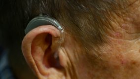 old man using hearing aids