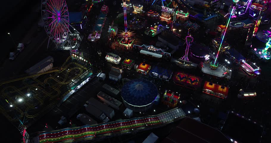Aerial of fair/carnival. slowly dollies forward to reveal carnival rides and lights at night. | Shutterstock HD Video #1020847942