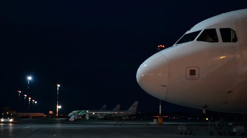Passenger aircraft on the platform of the night airport. Close-up

