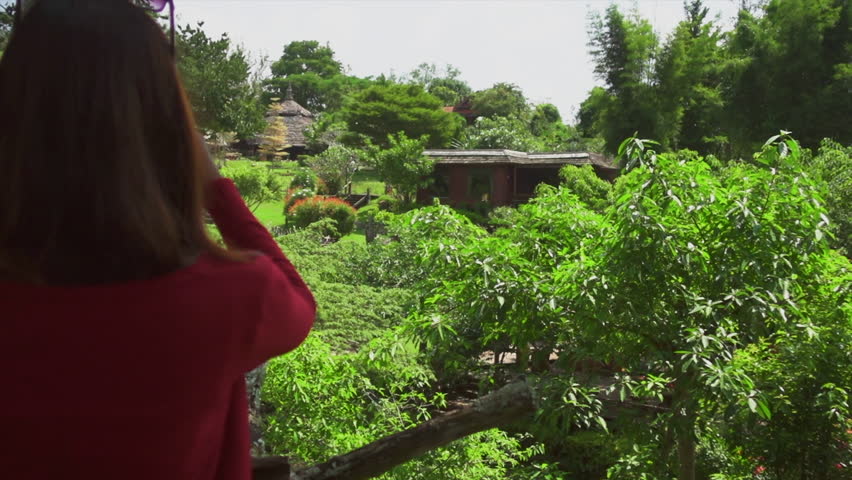 Girl in red jacket taking picture by phone from the Tree house viewpoint