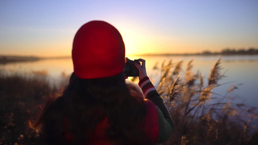 tourist teen girl traveler female photographer photographing, girl making photo of beach lake. Woman taking picture of camera at sunset. summer nature outdoors Travel tourism happy holidays photograph