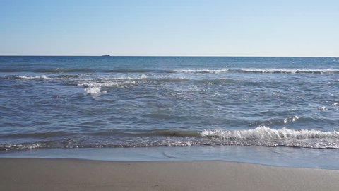 Ocean waves rolling into sandy shore
