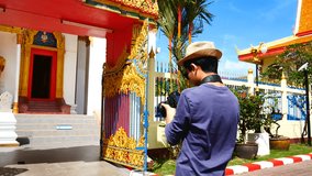 Travel Video A tourists blogger from Southeast Asia is walking in the old town to take a photo of temple in Phuket Old Town to write a tourist review. During vacation in travel concept