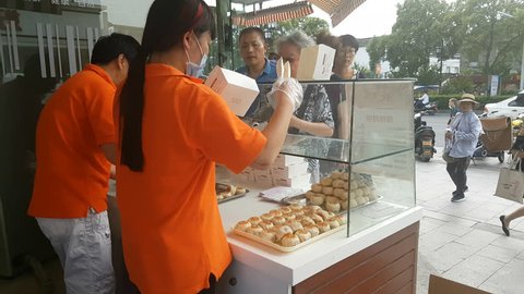 SUZHOU, CHINA - SEPTEMBER 2018: People queue at popular bakery selling special mooncakes during Mid-Autumn festival in Suzhou, China