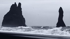 A video showing birds flying between two rocks at Black beach.