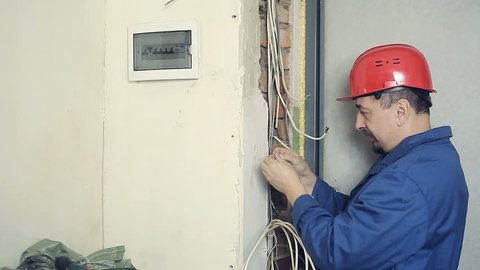 Male electrician performs installation work