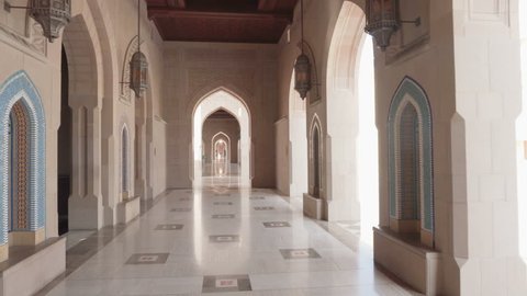 Beautiful arched passageway at the Sultan Qaboos Grand Mosque in Muscat, Oman. Wonderful interior of the Muslim place. Amazing Islamic architecture.
